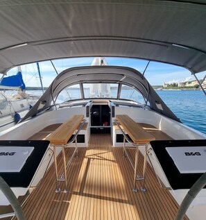 A boat deck with a covered area, a central table, and a view of the water. - Sun-Kissed Sailing Adventure in Istria, Croatia (Pula)