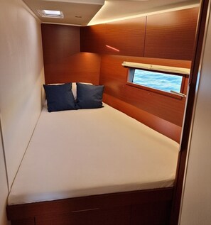 A compact cabin with a bed, a window with a view of the sea, and wooden paneling. - Sun-Kissed Sailing Adventure in Istria, Croatia (Pula)