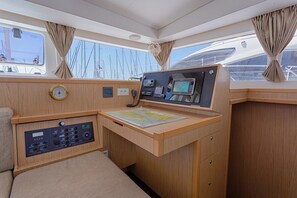Die Kommandozentrale einer Yacht mit einer Seekarte, einer Uhr und verschiedenen Bedienelementen.