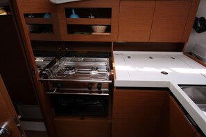 A compact kitchen with a stove, oven, and white countertop. - Sun-Kissed Sailing Adventure in Zadar, Croatia (Biograd na moru)