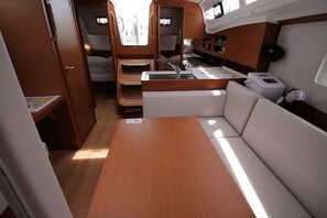 A compact interior with a dining area, kitchenette, and seating. - Sun-Kissed Sailing Adventure in Zadar, Croatia (Biograd na moru)