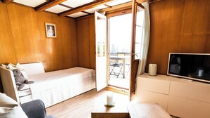 A cozy room with a bed, a sofa, a TV, and a small table. - Bürcher Haus 1. OG Süd-West Appartement/Fewo, Dusche, WC by Interhome (Riederalp)