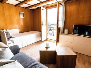 A cozy room with a bed, a sofa, a TV, and a small table. - Bürcher Haus 1. OG Süd-West Appartement/Fewo, Dusche, WC by Interhome (Riederalp)