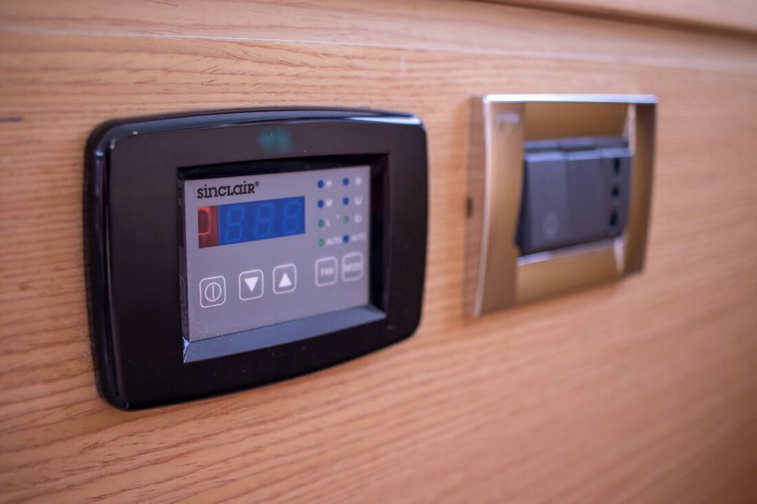 A control panel with a screen and buttons, likely for room amenities.