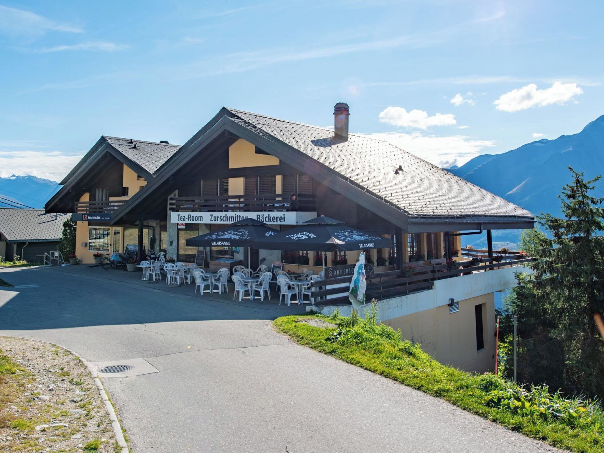 Un chalet de montagne doté d’un espace extérieur aménagé et offrant une vue sur les montagnes.