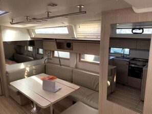 A compact RV interior with a kitchenette, seating area, and a small table.