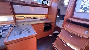 A compact kitchenette with a sink, stove, and storage cabinets. - Sun-Kissed Sailing Adventure in Sibenik, Croatia (Primošten)