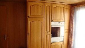 A room with a large wooden wardrobe, a built-in oven, and a door. - Abendrot 1. OG Süd-West Appartement/Fewo, Dusche oder Bad, WC by Interhome (Riederalp)