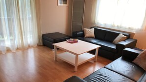 A living room with a black leather sofa, a white coffee table, and a black ottoman. - Abendrot 1. OG Süd-West Appartement/Fewo, Dusche oder Bad, WC by Interhome (Riederalp)
