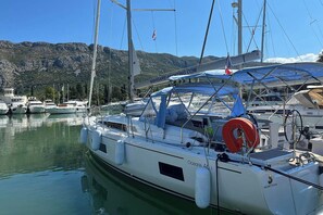A marina with boats docked, a clear sky, and a mountainous backdrop. - Dubrovnik Delight: A Sun-Kissed Sailing Experience (Komolac)