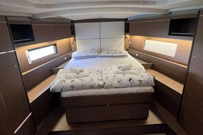 A compact, well-lit cabin with a bed, built-in storage, and a small window. - Dubrovnik Delight: A Sun-Kissed Sailing Experience (Komolac)