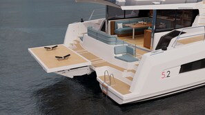Un yacht doté d’un espace repas, de sièges et du numéro 52 peint sur sa coque.