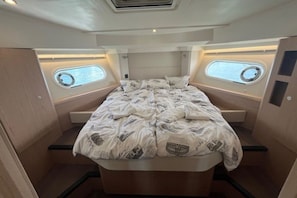 A compact, well-lit cabin with a bed, two small windows, and a built-in headboard. - Sibenik Sun-soaked Sailing: A Luxurious Croatian Voyage (Pirovac)
