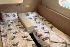 En liten, kompakt säng med en sänggavel och ett fönster.