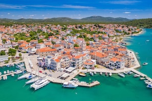 A coastal town with a marina, buildings with red roofs, and a clear blue sea. - Sibenik Sun-soaked Sailing: A Luxurious Croatian Voyage (Pirovac)
