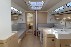 A compact interior with a kitchenette, seating area, and a bathroom. - Sun-Kissed Sailing Adventure in Istria, Croatia (Pula)