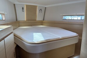 A compact RV interior with a bed, a small kitchenette, and a window providing natural light. - Sun-Kissed Sailing Adventure in Istria, Croatia (Pula)