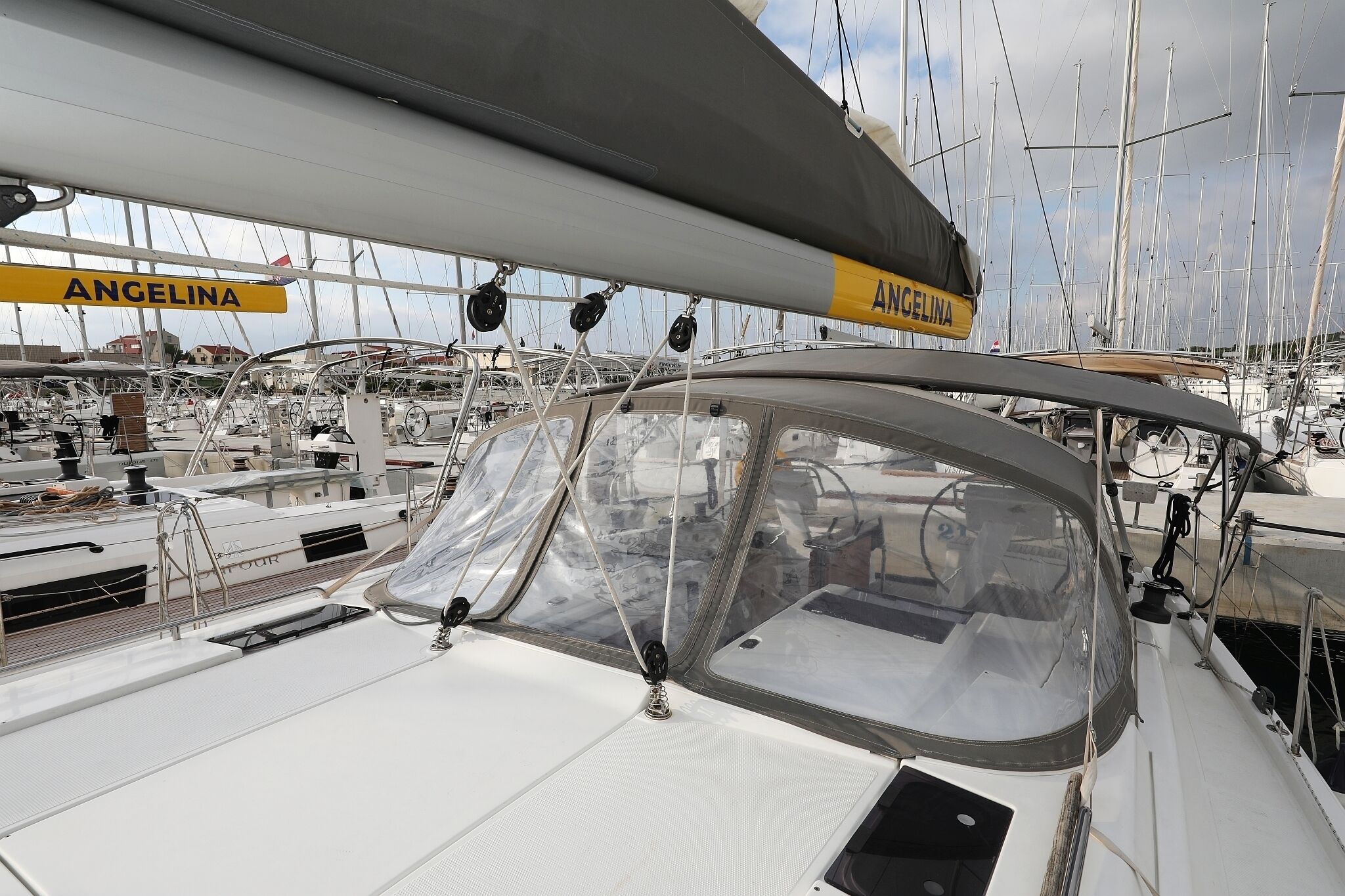 Un velero llamado 'Angelina' atracado en un puerto deportivo con varios barcos.