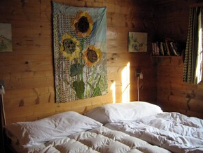 A room with a bed, a wall tapestry, and a bookshelf. - Sunneschy 1. OG Süd Appartement/Fewo, Dusche, WC 3 Zimmerwohnung, 6-Betten by Interhome (Riederalp)