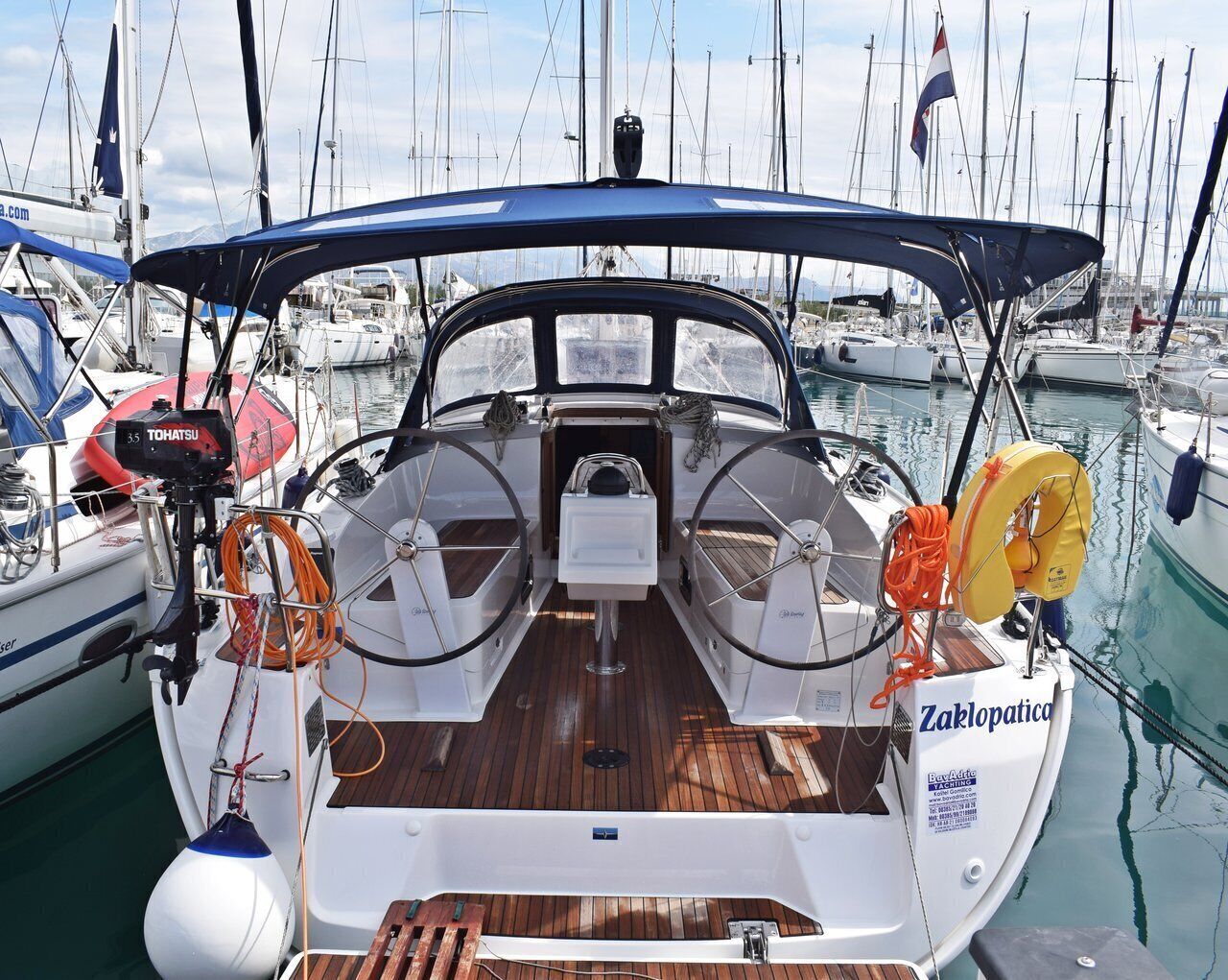 Ein Bootsdeck mit Steuer, Rettungsflossen und dem Markennamen 'Zablopatica'.