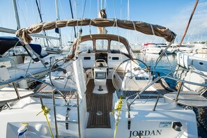 A sailboat docked in a marina with multiple boats, a steering wheel, and a name 'JORDAN' on the deck. - Sun-Kissed Sailing Adventure in Zadar, Croatia (Biograd na moru)