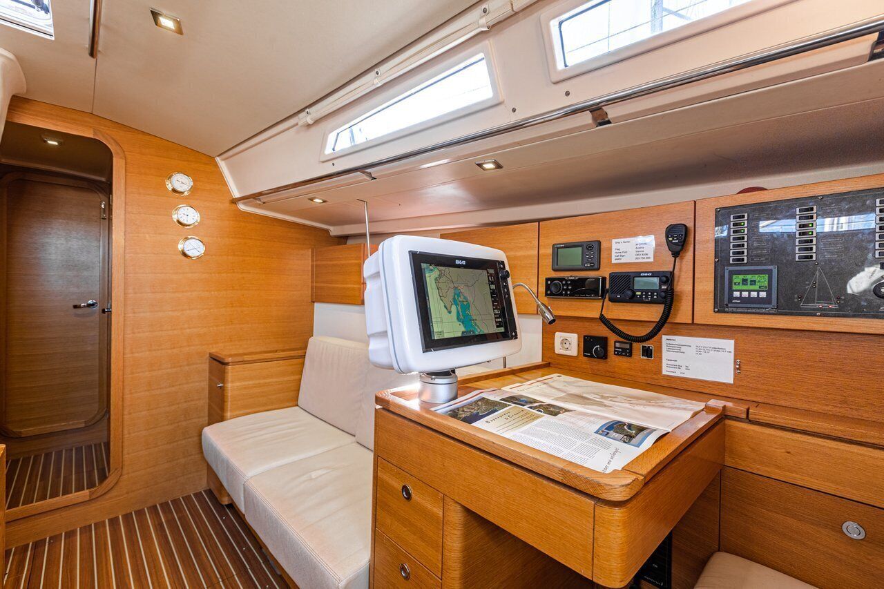 Eine Hütte mit einem Bett, einem Schreibtisch mit Computerbildschirm und einer Steuerung.'