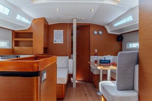A compact galley with a dining area, a small seating space, and a wooden finish. - Sun-Kissed Sailing Adventure in the Dodecanese Islands (Kos)