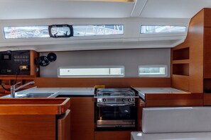 A compact galley with a stove, oven, and a small sink. - Sun-Kissed Sailing Adventure in the Dodecanese Islands (Kos)