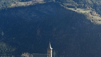 A mountain village with a church, houses, and a road.