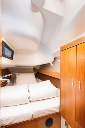 Ein gemütliches Blockhaus mit Etagenbett, einem kleinen Tisch und einem Holzschrank.