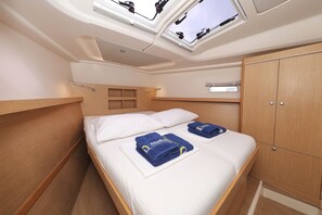 Habitació senzilla amb llit, armari, finestra clatell i una petita prestatgeria.