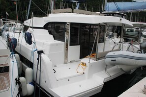 A white boat with a cabin, a small outboard motor, and a covered area at the stern. - Dubrovnik Delight: A Sun-Kissed Sailing Experience (Komolac)