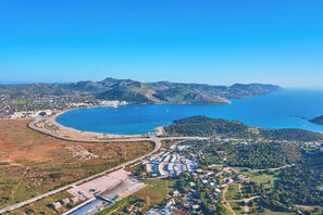 An aerial view of a coastal town with a marina, roads, and residential areas.