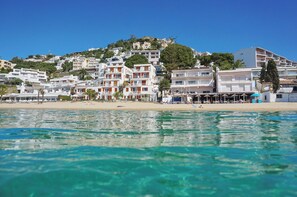 A coastal hotel with multiple floors, beach access, and a view of the sea.
