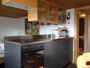 A compact kitchen with a built-in dishwasher, a coffee maker, and a microwave. - Sunneschy EG Süd Appartement/Fewo, Dusche, WC 2 1/2 Zimmerwohnung, 3-Betten by Interhome (Riederalp)