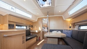Een ruimtelijk, goed verlicht interieur met een eethoek, zitgedeelte en kitchenette.