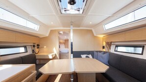 Een compact interieur met een centrale tafel, zitplaatsen en een dakraam.