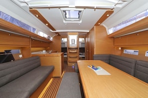 A compact interior with a central table, cushioned seating, and a skylight. - Sun-Kissed Sailing Adventure in Zadar, Croatia (Biograd na moru)