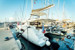 Ein Yachthafen mit mehreren vertäuten Booten, darunter eine weiße Yacht mit überdachter Deck und ein kleineres Motorboot.