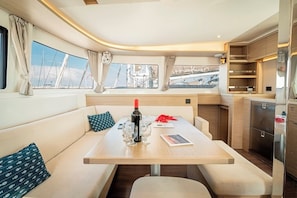 A compact, well-lit interior with a dining area, a kitchenette, and a view of the outside.