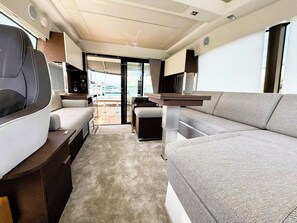 Ein kompaktes Wohnmobil-Interieur mit Küchenzeile, Essbereich und Sitzecke mit Blick ins Freie.