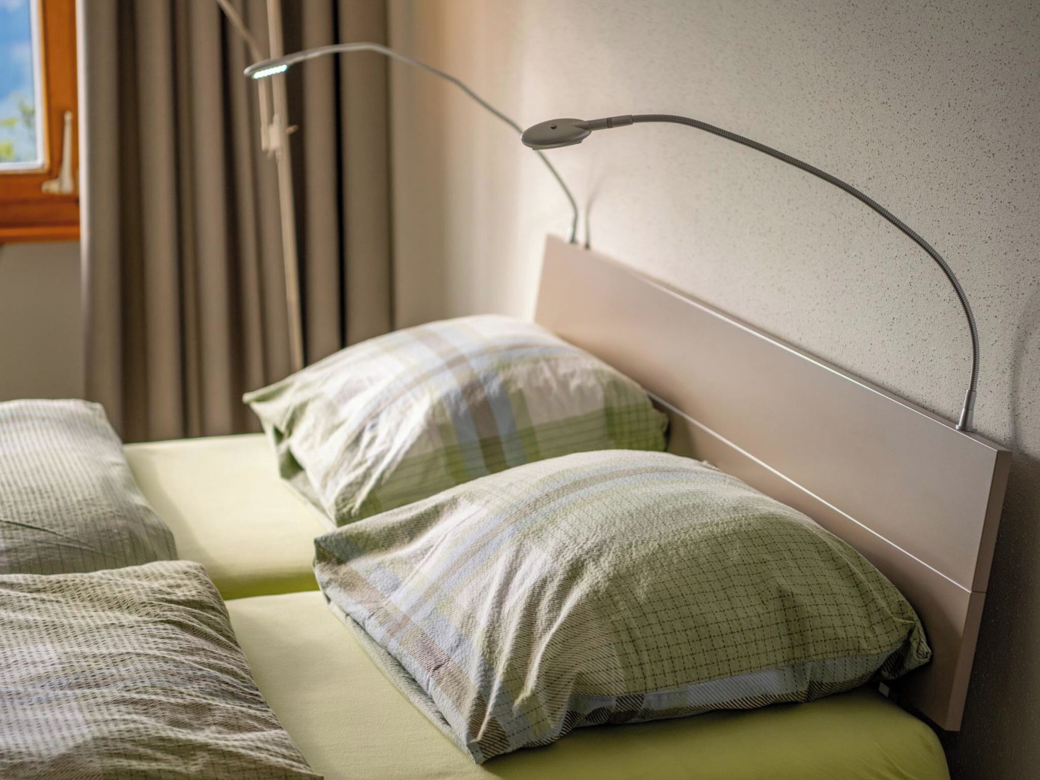 Ein Bett mit Kopfteil, zwei Kissen und einem Nachttisch.