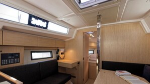 Een compact RV-interieur met een kitchenette, een zithoek en een klein tafeltje met boeken.