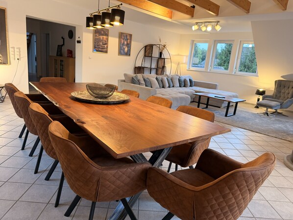 Un salón amplio con una gran mesa de comedor de madera, asientos cómodos y una chimenea acogedora.