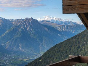 Blick auf Berge mit einer Holzhütte im Vordergrund.