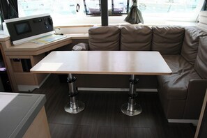A compact kitchen with a microwave, a small table, and a sofa.