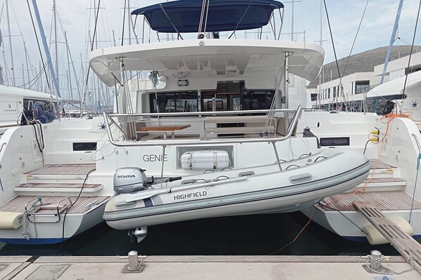 A white yacht named 'GENIE' docked at a marina with a covered deck area and a seating arrangement. - Sun-kissed Sailing Adventure in Split-Dalmatia, Croatia (Seget Donji)