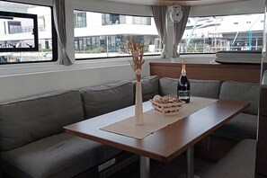 Ein modernes Interieur mit einer Couch, einem Holztisch, einer Vase und einer Champagnerflasche.
