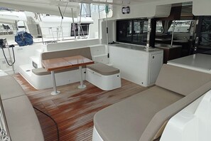 A modern boat interior with a dining area, seating, and a small kitchen. - Sun-kissed Sailing Adventure in Split-Dalmatia, Croatia (Seget Donji)