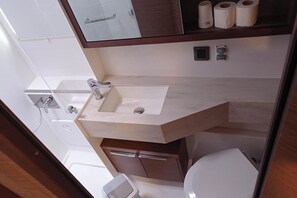 A bathroom with a sink, toilet, and a shelf with toilet paper. - Sun-kissed Sailing Adventure in Split-Dalmatia, Croatia (Seget Donji)